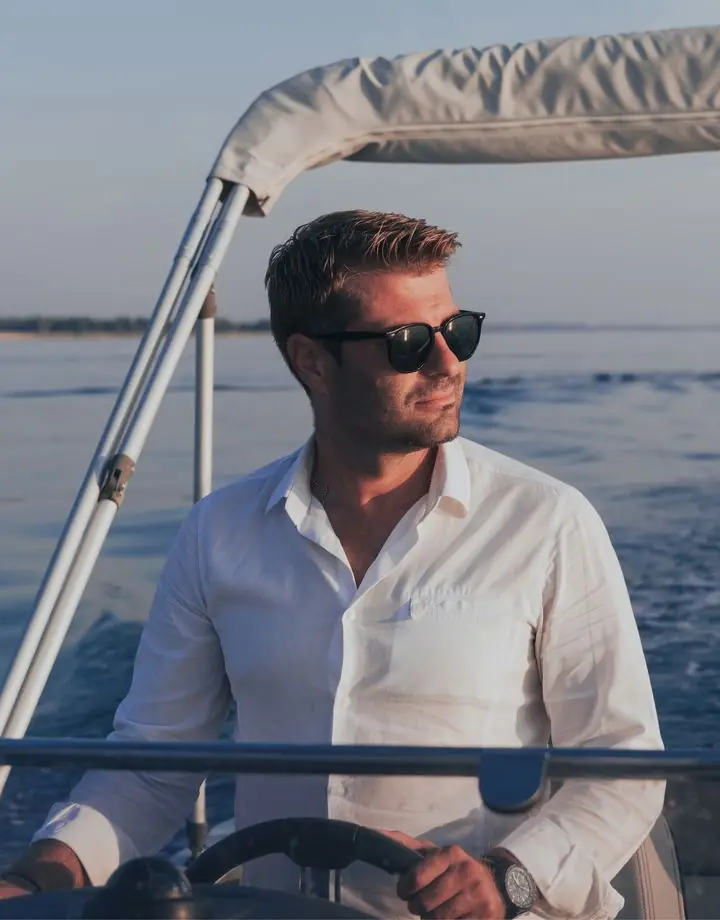 Man in sunglasses steers a speedboat at sea