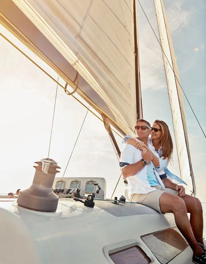Couple embracing on the bow of a sailboat in the sun